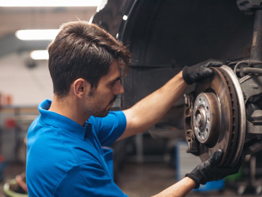 Technician inspecting Mazda brakes